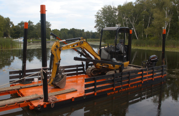 Motorized barge carrying a small excavator Barge Transport